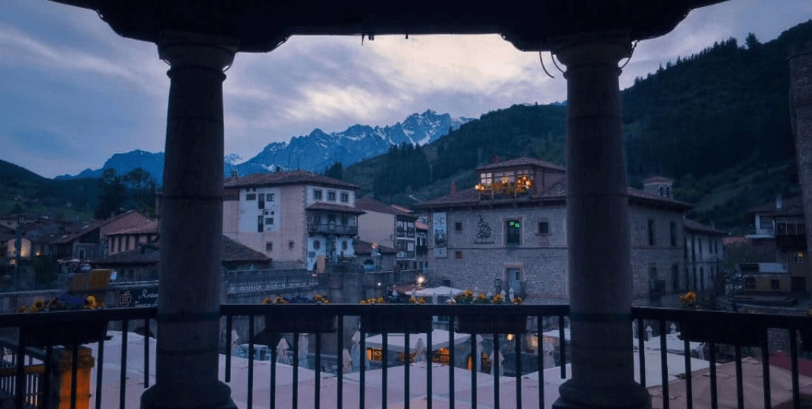 Vista del pueblo de Gandara desde el balcón del Albergue La Casa de Gandara, rodeado de montañas y naturaleza.