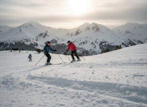 Esquiadores en pistas de Alto Campoo con montañas nevadas al fondo
