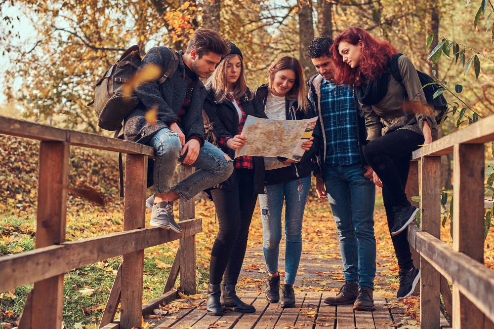 Estudiantes observando plantas y hojas en un taller educativo en un bosque de Cantabria en primavera
