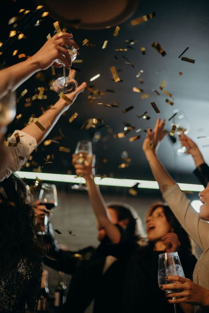 Grupo de amigos celebrando fin de año con confeti y alegría