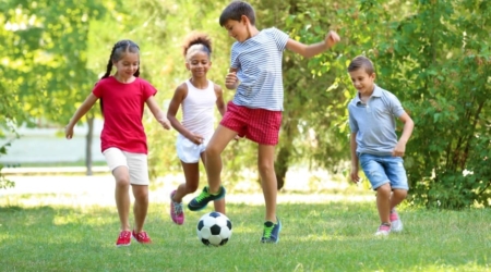 Niños jugando al fútbol en la naturaleza en Albergue la Casa de Gandara, un entorno ideal para familias y actividades al aire libre. Aventuras al aire libre disfruta del Verano en Cantabria